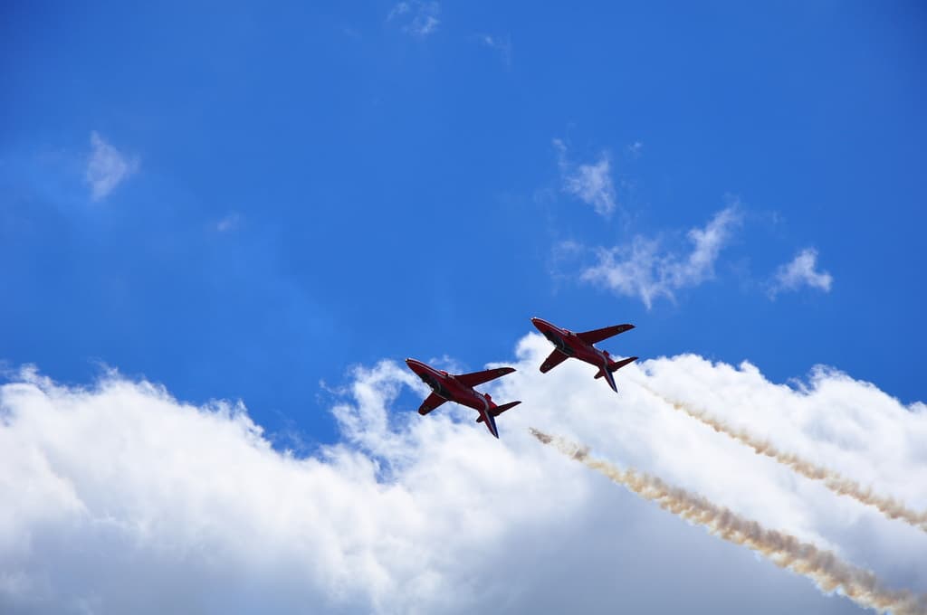 Zwei Flugzeuge am wolkenverhangenen Himmel.