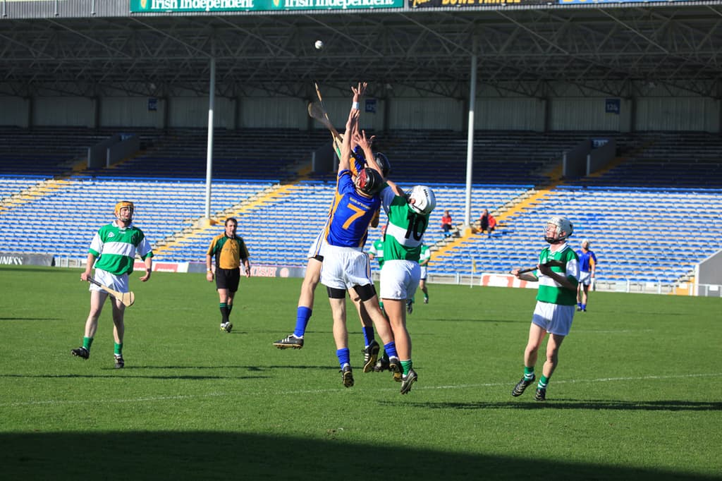 Menschen bei einem Spiel auf einem Feld mit einem Stadion im Hintergrund.