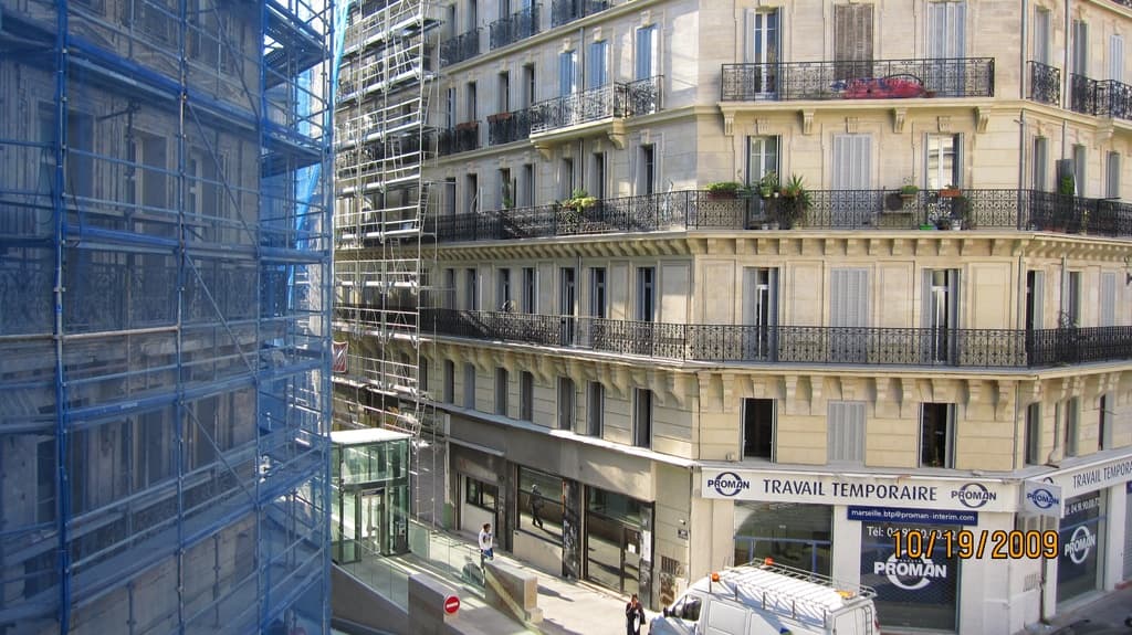 Ein großes Gebäude in Bau auf der linken Seite, mit einem Geschäft auf der unteren rechten Seite.