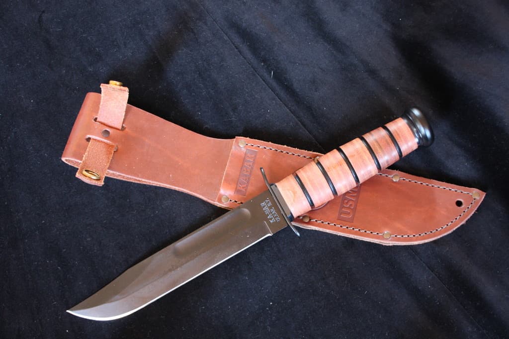 Ein Messer und seine Hülle werden auf einem schwarzen Tuch platziert.