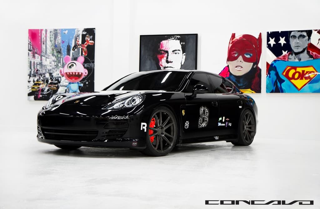 Ein schwarzer Nissan-Sportwagen mit Cartoon-Postern im Hintergrund und einer kleinen Inschrift unten.