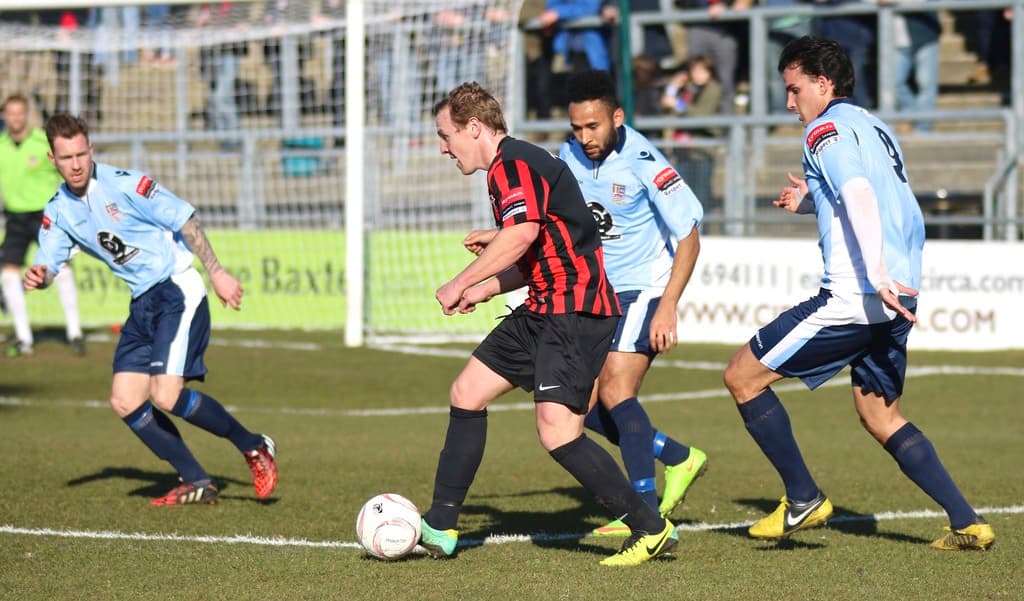 Eine Gruppe von Menschen, die mit einem Fußball auf einem Feld spielt.