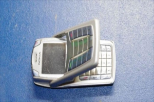 Ein Mobiltelefon liegt auf dem Boden mit einem blauen Hintergrund.