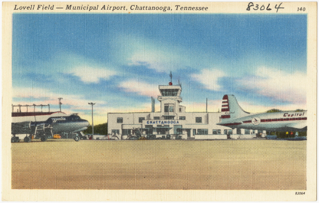 Ein Gebäude mit Antennen auf dem Dach, flankiert von Flugzeugen auf beiden Seiten.