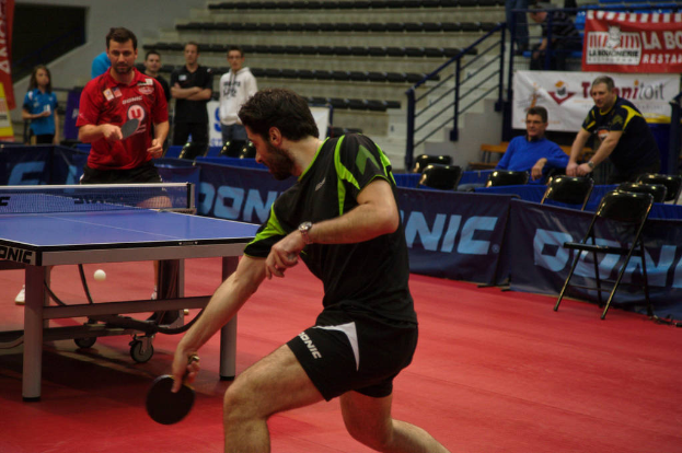 Eine Gruppe von Menschen in verschiedenen Farben, darunter schwarz, weiß und blau, versammelte sich um einen Tisch mit einem Spiel in Arbeit, mit Stühlen und einer Treppe im Hintergrund.