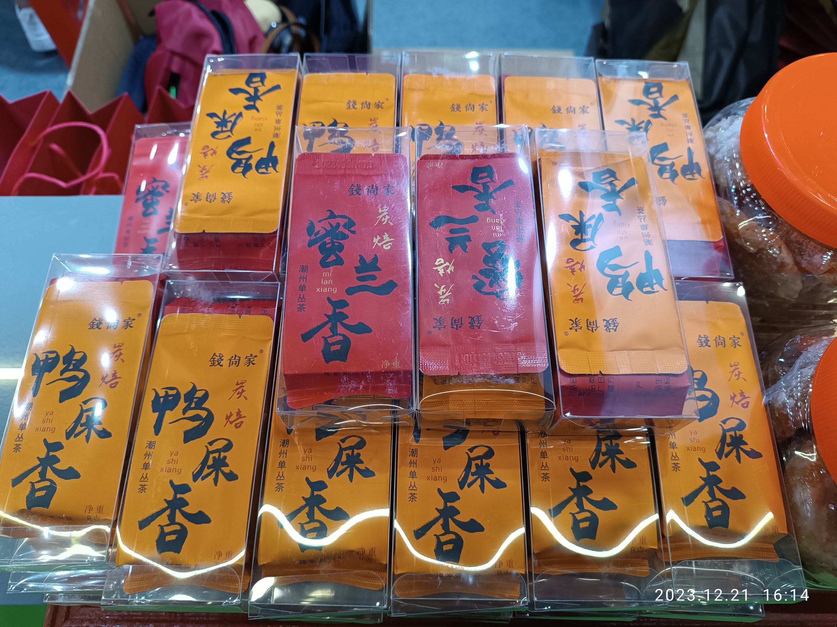 Ein Tisch mit verschiedenen verpackten Lebensmitteln und Gegenständen bei einer Feier zum chinesischen Neujahr, im Hintergrund steht eine Person.