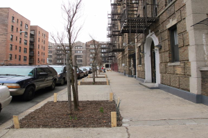 Eine spärlich bebaute Stadtkulisse mit wenigen Autos und Gebäuden im rechten Eck und einigen anderen Gebäuden im linken Eck.