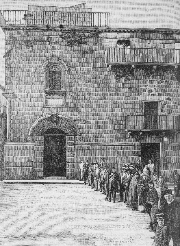 Schwarzes und weißes Foto einer Gruppe von Menschen, die vor einem Gebäude mit Fenstern, Geländern und einer Tür stehen, mit Text unten, der "Jüdische Gefangene am Eingang zur Synagoge in Jerusalem" lautet.
