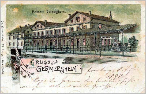 Schwarz-weiß-Postkarte vom Bahnhof Germersheim in Deutschland, die ein Bahnhofsgebäude, Menschen, Fahrzeuge, Bäume, einen Zaun, einen Straßenmast und einen bewölkten Himmel zeigt.