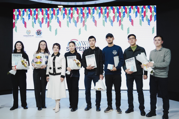 Gruppe von Menschen auf einer Bühne mit Bücher und Blumensträuße haltend, mit einem Bildschirm im Hintergrund, der "Yogyakarta International School of Science and Technology" anzeigt.