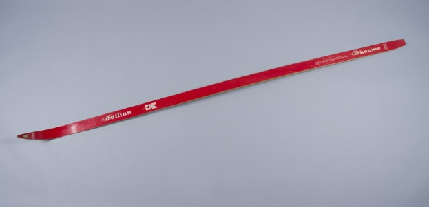 Rote Skier mit weißer Schrift darauf auf einer weißen Fläche.