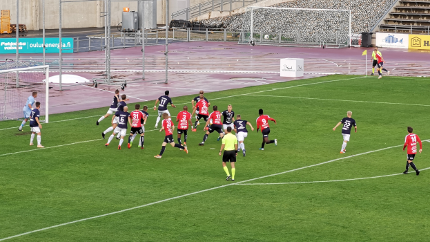 Eine Gruppe von Menschen, die Fußball auf einem Feld spielen.