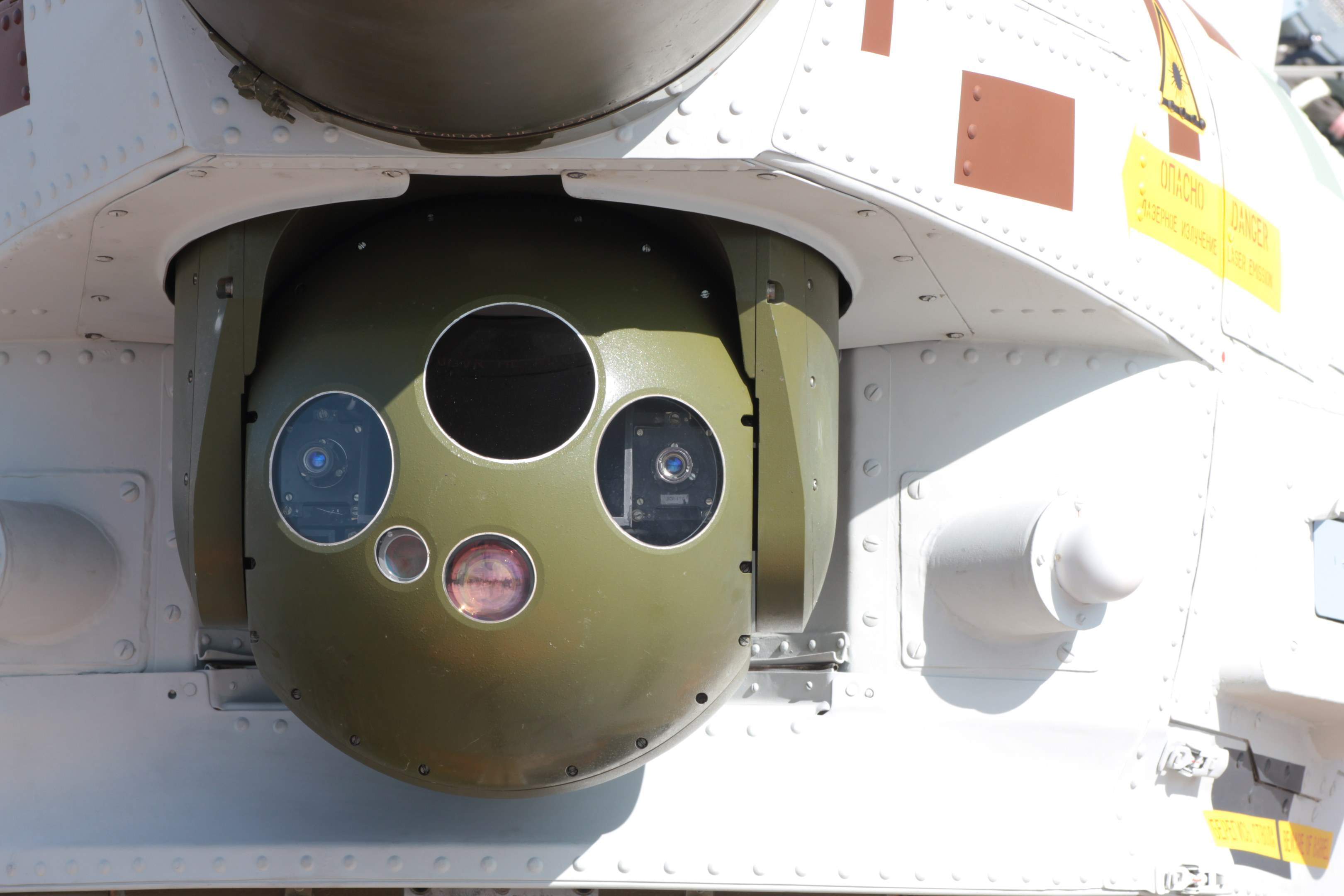 Nahaufnahme eines Militärfahrzeugs mit einer runden, grünen und weißen Rakete, die seitlich auf einem Metallrahmen montiert ist.
