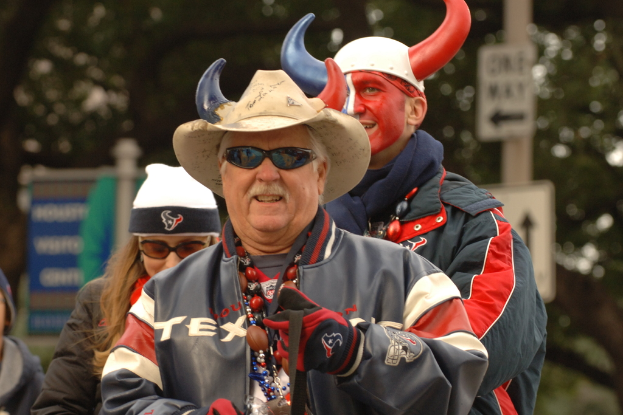 Eine Gruppe von Menschen, einige mit Mützen und einige mit Brillen, mit Schildern und einem Pfahl im Hintergrund.