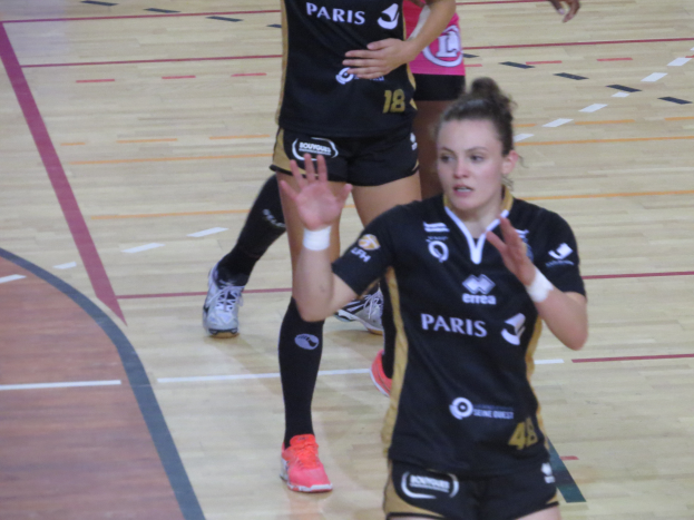 Eine Gruppe von Frauen in Sportkleidung beim Volleyballspielen auf einem Platz.