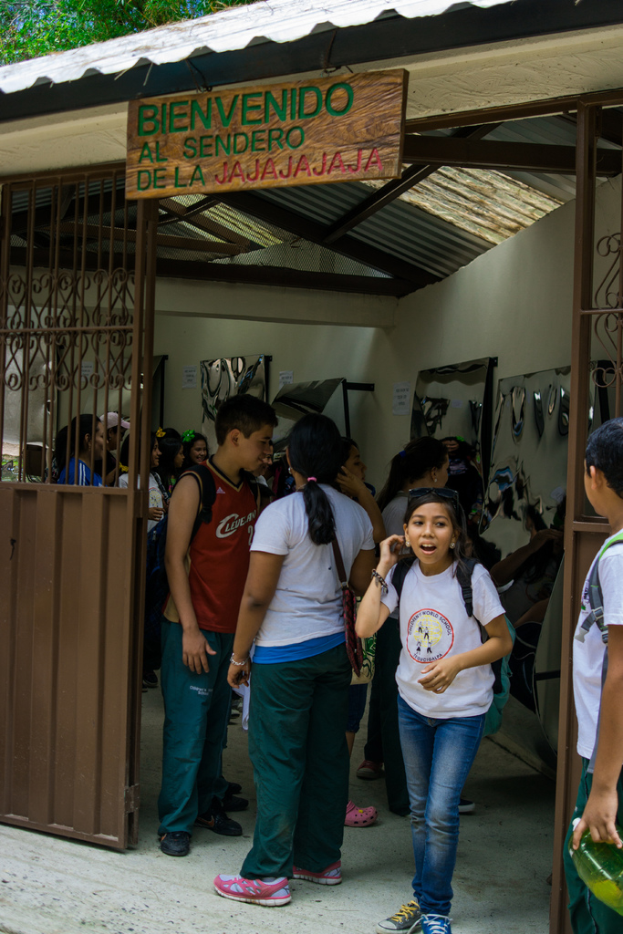 Ein Geschäft mit einer Eisenblechfassade, einem Schild mit Text oben drauf und Menschen drinnen.