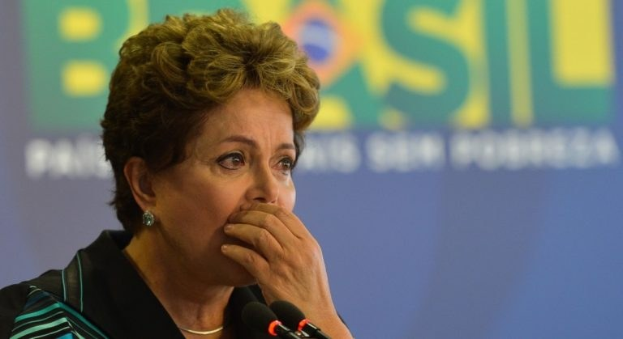 Brasiliens Präsidentin Dilma Rousseff spricht bei einer Pressekonferenz in Rio de Janeiro vor einer textgefüllten Tafel mit Mikrofonen im Bild unten.