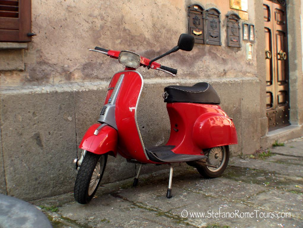 Ein roter E-Scooter steht vor einem Haus mit einer T√ľr und Fenstern auf einer Stra√e mit Text unten.
