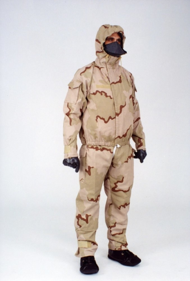 Eine Person in einem Ganzkörper-Schutzanzug mit Kapuze und Maske steht vor einem weißen Hintergrund.