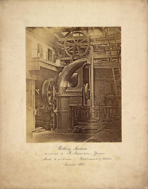 Alte Industrieanlage mit einem zentralen Rad, umgeben von Geräten, in einer Fabrikumgebung.