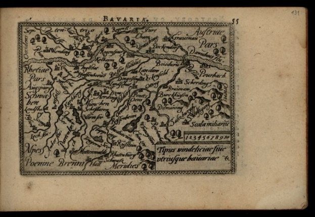 Altes Buch mit einer detaillierten Karte von Bayern auf dem Cover vor einem schwarzen Hintergrund.