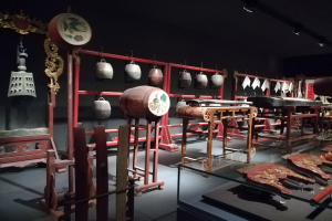 Ein Museumsraum voller verschiedener Musikinstrumente, darunter eine Trommel, mit Deckenbeleuchtung und einer Wand im Hintergrund.