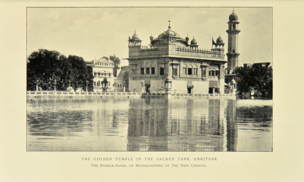 Der goldene Tempel in Amritsar ist von Wasser, Bäumen und einem klaren Himmel umgeben und zeigt Text am unteren Bildrand.