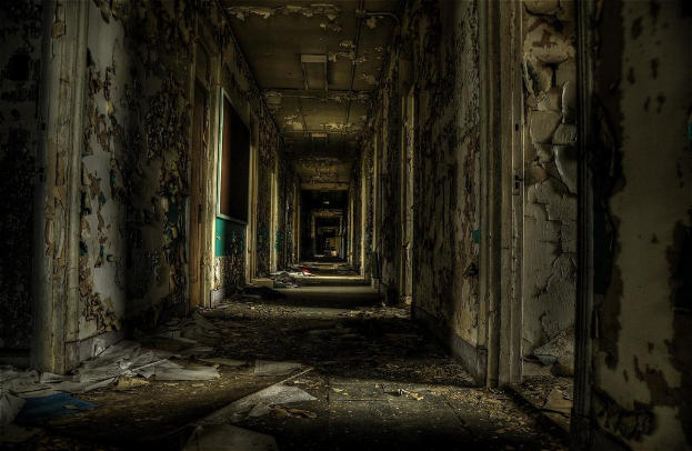 Ein altes Gebäude mit verstreuten Papieren auf dem Boden und einer Tafel an der linken Seitenwand.