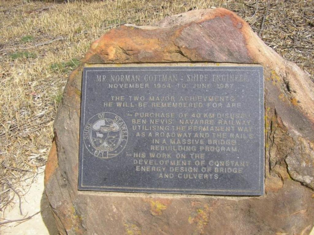 Eine Marmorplatte auf einer Steinfläche mit Gras im Hintergrund.