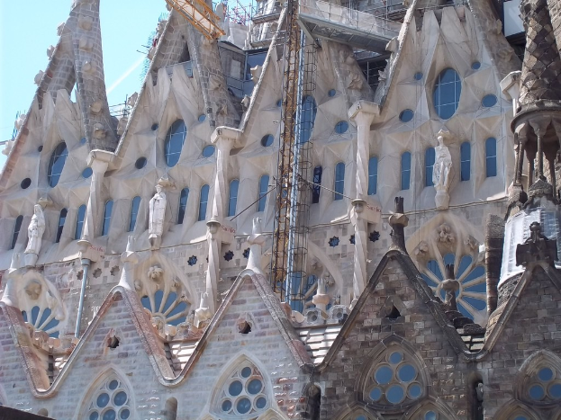 Ein unter Baugerüst stehender Bau mit mehreren Skulpturen unter einem klaren Himmel.