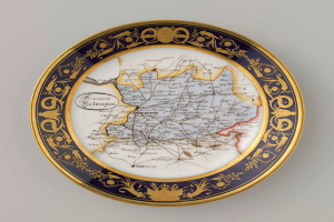 Eine weiße Platte mit einer detaillierten Deutschlandkarte, verziert mit kunstvollen Designs und Texten.