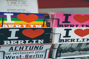 Ein Gestell mit verschiedenen Büchern und Postern mit der Aufschrift "Ich liebe Berlin" vor einem unscharfen, träumerischen Hintergrund.