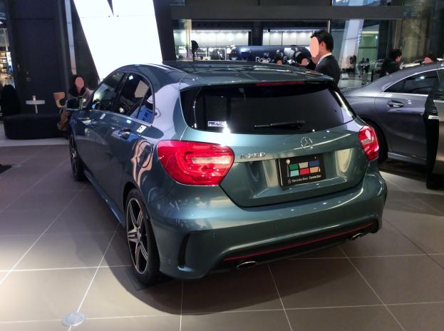 Ein Mercedes-Benz A-Klasse-Hatchback mit glänzender schwarzer Lackierung und Chromakzenten, das auf der IAA in Frankfurt gezeigt wird, umgeben von Menschen.