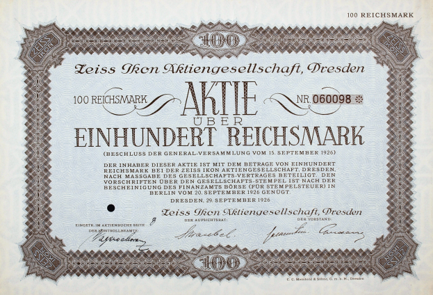 Ein altes deutsches Aktienzertifikat mit schwarzem Rand und der Aufschrift "Aktie über Einhundert Reichmark"