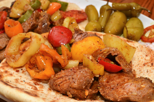 Ein Teller mit Tomaten, Chilischoten und Hähnchenstücken.