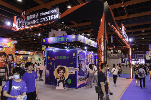 Eine Gruppe von Menschen, die durch den Ausstellungssaal einer Gaming-Messe in China gehen, einige tragen Taschen und halten Gegenstände, mit Displaytafeln, Deckenbeleuchtung und Teppichboden.