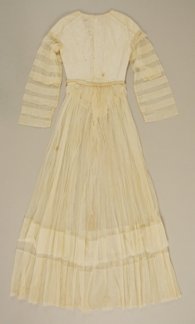 Ein weißes, langärmeliges Kleid mit einer bauschigen, bodenlangen Röcke auf einer weißen Oberfläche, das einen hohen Taillenbund, voluminösen Stoff und einen dezenten Glanz aufweist.