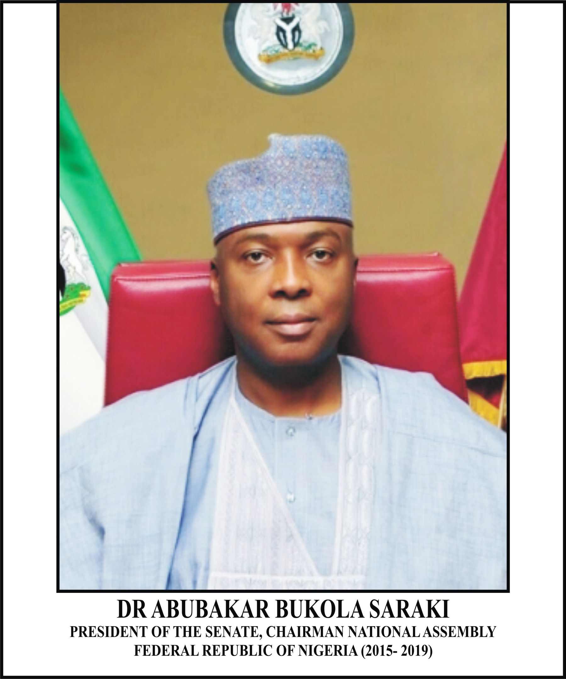 Dr. Abubakar Bukola Saraki, Präsident des Senats und Vorsitzender der Nationalversammlung, sitzt in einem blauen Anzug und Hut mit zwei Flaggen und einem Logo dahinter und einem Rahmen mit Namen unten.