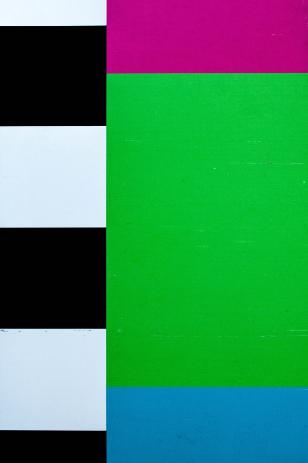 Ein Fernseher, der ein lebendiges Bild mit Grün-, Pink-, Blau- und Schwarzfarben anzeigt.