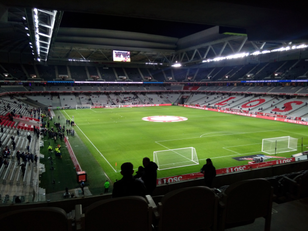 Großes Stadion voller Zuschauer bei einem Fußballspiel im Estadio Santiago Bernabeu in Madrid, Spanien, unter Stadionbeleuchtung mit einem Bildschirm über dem Feld.